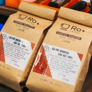 Home Close-up of premium coffee packaging highlighting Arabica beans with detailed labels in a vibrant setting.